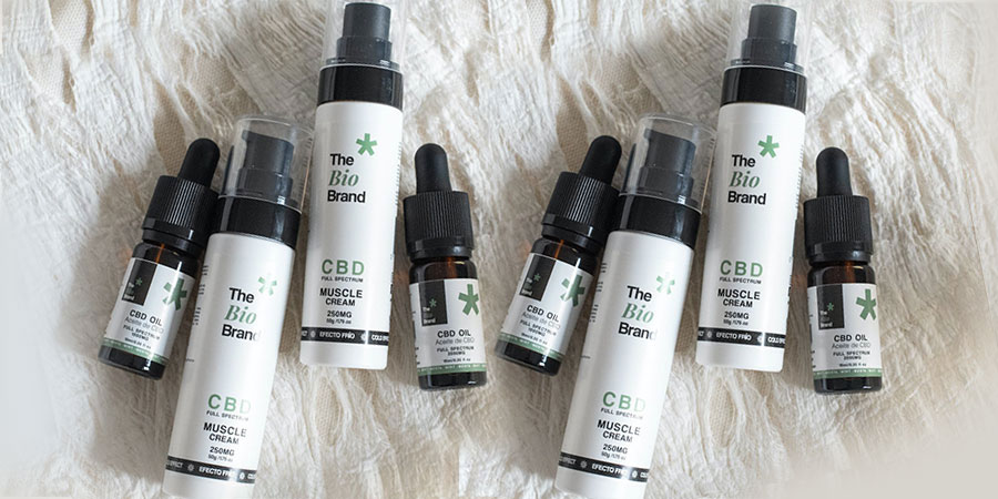 several bottles of CBD oil and CBD cream on top of a white cloth